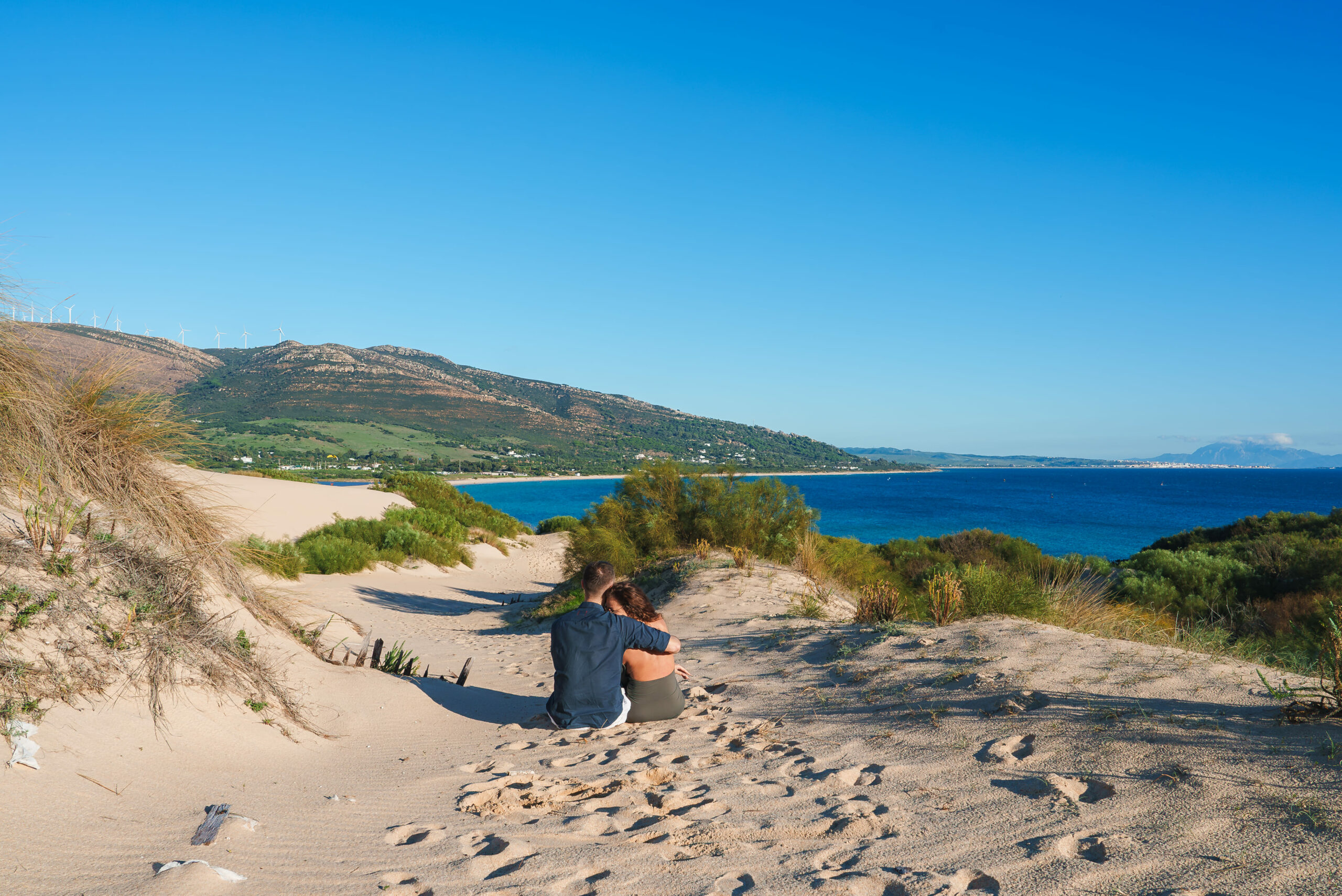 imagen de una pareja sentada en las dunas de Bolonia en Tarifa
